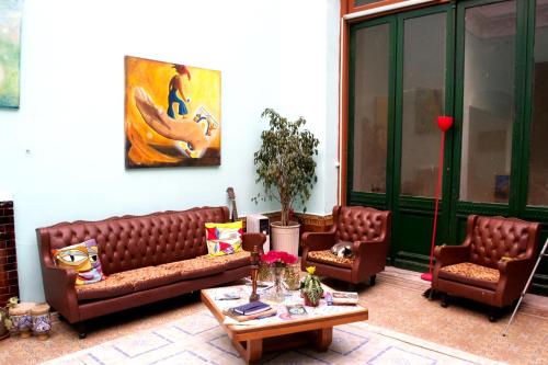 a living room with brown leather couches and a table at El Secreto Casa Art in Montevideo