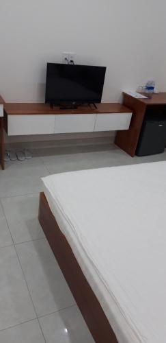 a room with a bed and a desk with a laptop at Sao Kim in Cà Mau