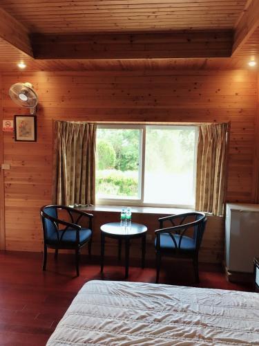 a bedroom with a bed and a table and a window at Yuli Sun Homestay in Yuli