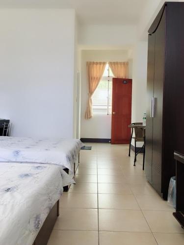 a room with two beds and a table and a window at Yuli Sun Homestay in Yuli