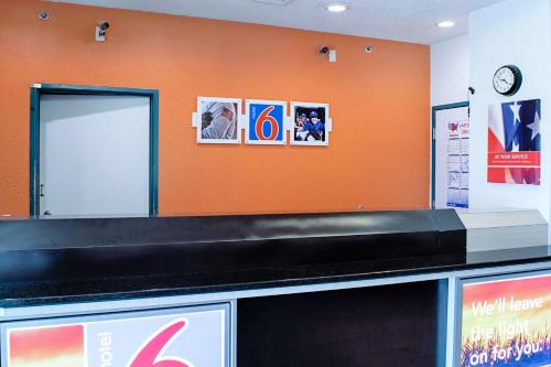 an orange wall with a baggage claim counter at Motel 6-Seymour, IN - North in Seymour