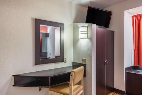 チャタヌーガにあるMotel 6 Chattanooga Downtownのテーブル、鏡、椅子が備わる部屋