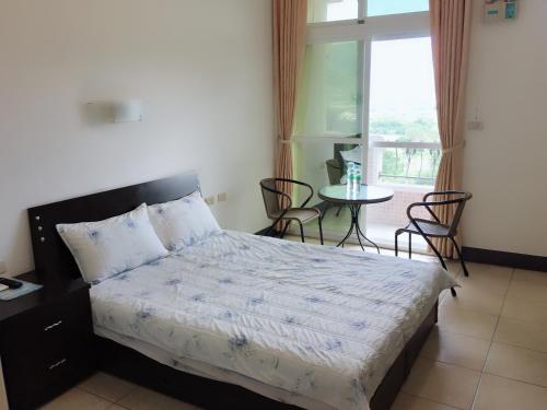 a bedroom with a bed and a table with chairs at Yuli Sun Homestay in Yuli