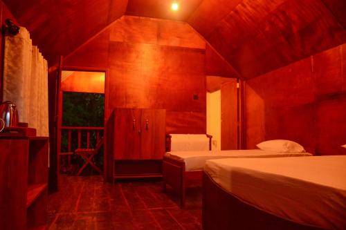 a bedroom with two beds in a room with at Sinharaja Forest Gate in Deniyaya
