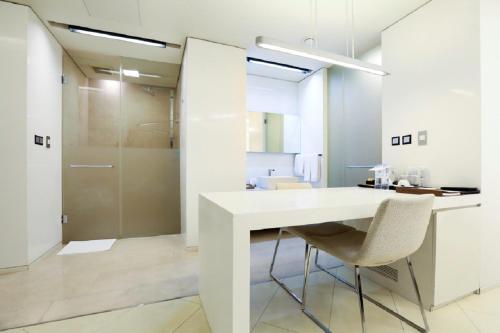 uma cozinha branca com uma mesa e cadeiras brancas em The Classic 500 Pentaz Executive Residence em Seul