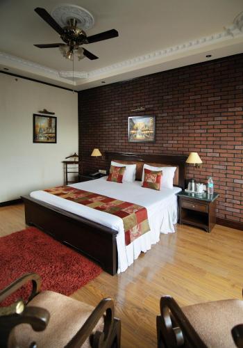 a bedroom with a large bed and a brick wall at Hotel Diplomat Residency in New Delhi