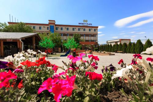 Ein paar rosa Blumen vor einem Gebäude in der Unterkunft Infinity Plaza Hotel in Atyrau