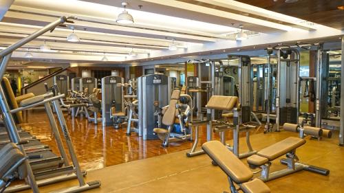 a gym with rows of exercise equipment on the floor at The Manila Hotel in Manila