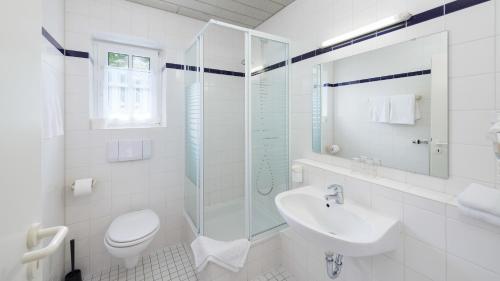 a white bathroom with a sink and a shower at Motel Hormersdorf in Hormersdorf