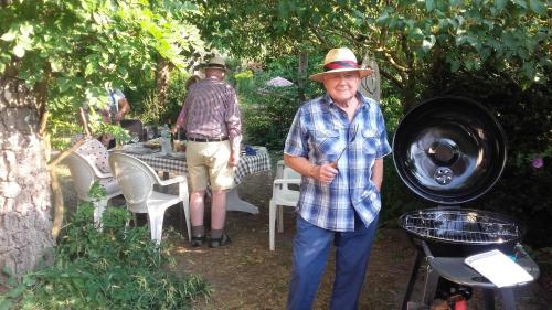 un hombre mayor y una mujer de pie en un jardín en Chambres du Jardin Fleuri, en Saint-Aubin-lès-Elbeuf