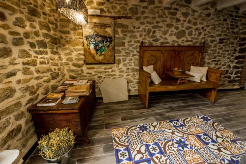 a room with two beds and a table in a stone wall at Casa Rural El Portillo in Cantavieja