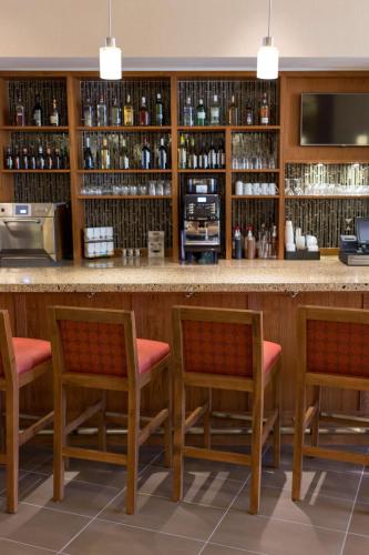 a bar in a restaurant with four chairs and a counter at Hyatt Place Charleston - Historic District in Charleston