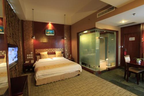 a bedroom with a bed and a glass shower at Kunming Golden Spring Hotel in Kunming