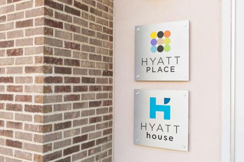 two signs on a brick wall with the hyatt place logo at Hyatt House Charleston - Historic District in Charleston