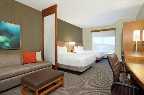 a hotel room with two beds and a couch at Hyatt Place Houston/Katy in Katy