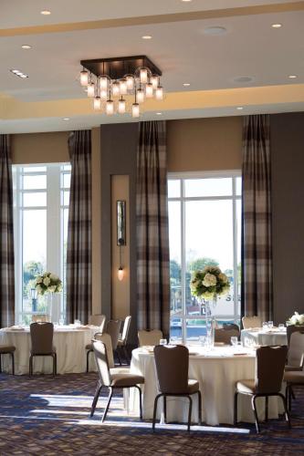 a dining room with tables and chairs and windows at Hyatt House Charleston - Historic District in Charleston