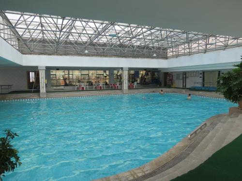 a large swimming pool in a large building at Kunming Golden Spring Hotel in Kunming