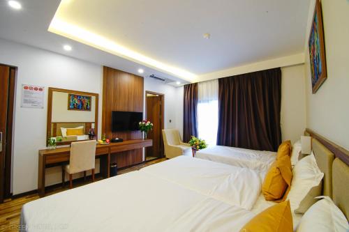 a hotel room with a bed and a desk at Green Hadong Hotel in Hà Ðông
