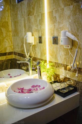 a bathroom with a sink with pink flowers on it at Green Hadong Hotel in Hà Ðông