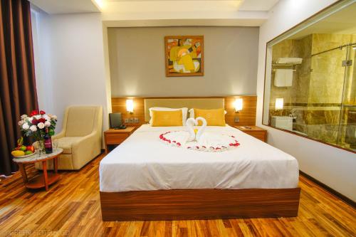 a hotel room with a bed and a chair at Green Hadong Hotel in Hà Ðông