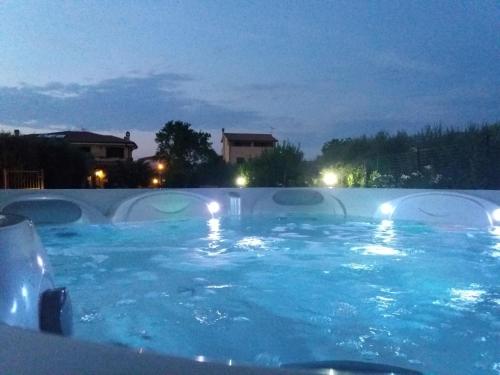 a swimming pool with blue water at night at Appartamenti Gli Ulivi Di Maremma in Gavorrano