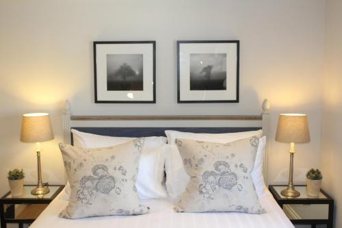 1 dormitorio con 1 cama con 2 cuadros en la pared en The Cottage at The Dene en Chichester