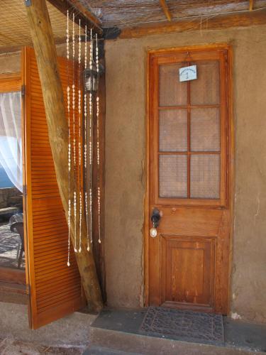 a house with a wooden door and a window at Hospedaje Boutique Ckamur in Caldera