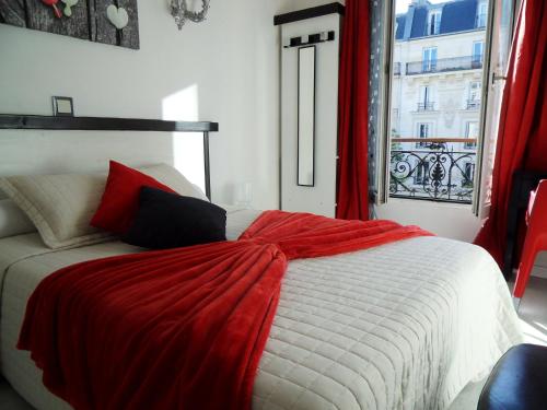 una camera da letto con un letto con una coperta rossa sopra di Camelia Prestige - Place de la Nation a Parigi