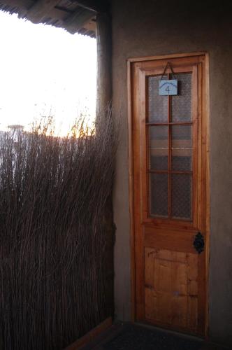 a door in the side of a house with tall grass at Hospedaje Boutique Ckamur in Caldera