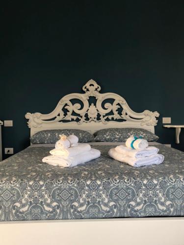 1 cama con toallas y marco de cama blanco en Pompei TERAFI Home, en Pompeya