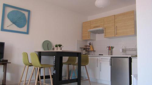 una cucina con tavolo e sedie in una stanza di Bleu de Thau a Balaruc-les-Bains
