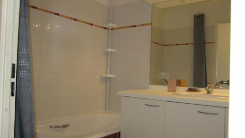 un bagno con vasca, lavandino e specchio di Bleu de Thau a Balaruc-les-Bains