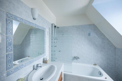 a bathroom with a sink and a tub and a mirror at Château du Jard in Chaumont-en-Vexin