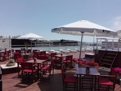 
a patio area with tables, chairs and umbrellas at Evenia President in Salou
