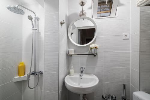 a white bathroom with a sink and a mirror at Urban Garden in Sofia