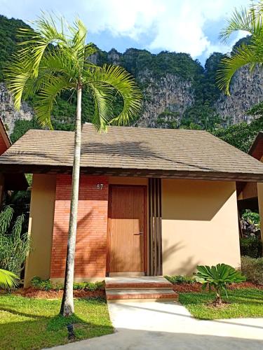 a small house with a palm tree in front of it at Aonang Hill Krabi-SHA Extra Plus in Ao Nang Beach