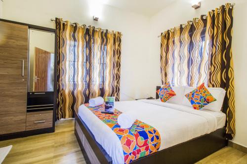 a bedroom with a large bed with curtains at FabExpress Grand Castle Hill Resorts Ooty Boat House in Ooty