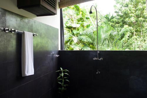 a bathroom with a shower with a window at Salt House in Hiriketiya