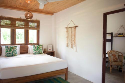 a bedroom with a white bed and a window at Salt House in Hiriketiya
