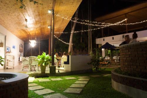 a patio with lights and people sitting at a table at Salt House in Hiriketiya