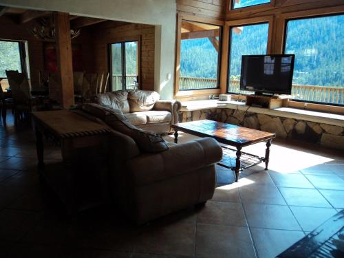 a living room with a couch and a tv and windows at Bosques de Monterreal in Mesa de las Tablas