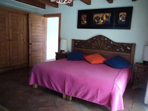 a bedroom with a large bed with purple sheets at Bosques de Monterreal in Mesa de las Tablas