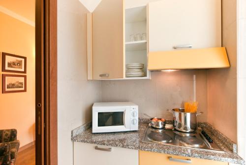 a small kitchen with a microwave and a stove at Residence Carl&Do in Baveno