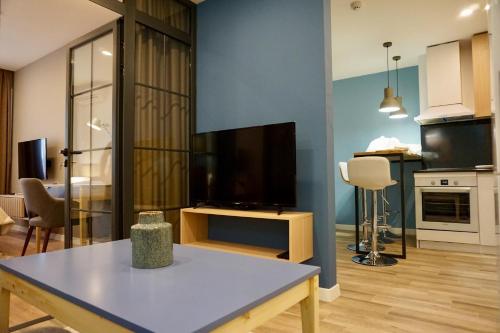 a living room with a flat screen tv and a table at North Avenue Loft Apartments in Yerevan