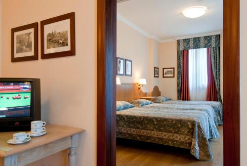 a hotel room with a bed and a television at Residence Carl&Do in Baveno