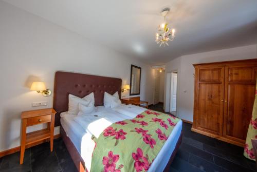 a bedroom with a large bed with a green blanket at Villa Beilstein in Beilstein