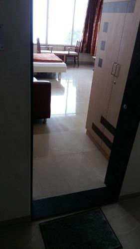 a mirror reflection of a room with a table and a door at Tranquil Treasure in Panchgani