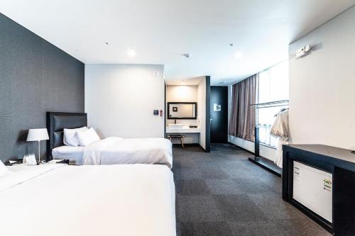 a hotel room with two beds and a television at Gangneung Tourist Hotel in Gangneung