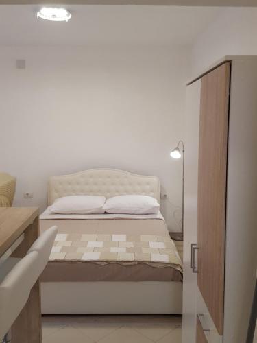 a bedroom with a bed and a white wall at Studio Apartman D&D in Banjole