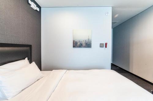 a bedroom with a bed and a painting on the wall at Gangneung Tourist Hotel in Gangneung
